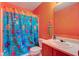 Orange bathroom with orange walls, a fun shower curtain, and a single sink vanity at 13295 Patriotic Way, Fishers, IN 46037