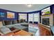 The living room features hardwood floors, a stone fireplace, natural light, and a comfortable sofa at 13295 Patriotic Way, Fishers, IN 46037