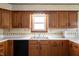 Traditional kitchen featuring wood cabinets, stainless steel sink, and bright window at 133 W Us Highway 52, Fountaintown, IN 46130