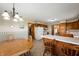 Eat in kitchen featuring wood cabinets, white appliances, a chandelier, and a breakfast bar at 133 W Us Highway 52, Fountaintown, IN 46130