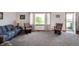 Cozy living room with carpet, comfortable seating, a large window, and an exterior door at 133 W Us Highway 52, Fountaintown, IN 46130