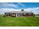 Quaint single-story home featuring a well-manicured lawn, brick exterior, and inviting bench seating at 133 W Us Highway 52, Fountaintown, IN 46130