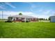 Charming single-story brick house surrounded by a lush green lawn and complemented by blossoming shrubbery at 133 W Us Highway 52, Fountaintown, IN 46130