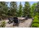 Relaxing backyard patio features a stone fire pit surrounded by Adirondack chairs at 13309 Carmichael Ln, Carmel, IN 46074