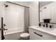 Stylish bathroom featuring white subway tile, a striped shower curtain, and modern black fixtures at 13309 Carmichael Ln, Carmel, IN 46074