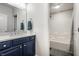 Bathroom featuring blue vanity, marble countertop, and shower-tub combo at 13309 Carmichael Ln, Carmel, IN 46074