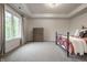 Airy bedroom with tray ceilings, a wrought iron bed frame, and a large window overlooking the yard at 13309 Carmichael Ln, Carmel, IN 46074