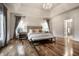 Well lit main bedroom with hardwood floors, crown molding, and ensuite bath at 13309 Carmichael Ln, Carmel, IN 46074