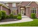 Elegant brick facade with a detailed entryway, complemented by manicured landscaping at 13309 Carmichael Ln, Carmel, IN 46074
