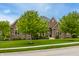 Inviting brick home with lush greenery and mature trees at 13309 Carmichael Ln, Carmel, IN 46074