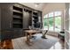 Study features custom bookshelves, a hardwood desk, and a large window for natural light at 13309 Carmichael Ln, Carmel, IN 46074