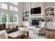 Living room with built-in shelves, large windows, fireplace and TV at 13309 Carmichael Ln, Carmel, IN 46074