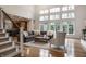 A large living room with hardwood floors, high ceilings, and many windows at 13309 Carmichael Ln, Carmel, IN 46074