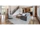 Open-concept living room flowing to the kitchen with hardwood floors and staircase at 13309 Carmichael Ln, Carmel, IN 46074
