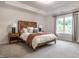 Bright bedroom boasts a wooden accent wall, tray ceiling, and large window with a view at 13309 Carmichael Ln, Carmel, IN 46074