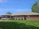 Spacious backyard featuring a covered porch, patio area, and lush green lawn at 1515 Renee Dr, Plainfield, IN 46168