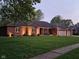 A single-story brick home on a lush green lawn with mature trees in a quiet neighborhood at 1515 Renee Dr, Plainfield, IN 46168
