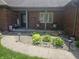 Inviting front porch with a 'welcome' sign, seating, decorative pillows, and landscaped surroundings at 1515 Renee Dr, Plainfield, IN 46168
