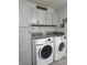 This laundry room features updated gray cabinets with granite countertops and modern washer and dryer at 1515 Renee Dr, Plainfield, IN 46168