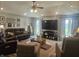 A spacious living room features hardwood floors, ceiling fan, large TV, recessed lighting, and comfortable seating at 1515 Renee Dr, Plainfield, IN 46168
