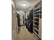 An organized walk-in closet features built-in shelving, hanging rods and carpeted floors at 1515 Renee Dr, Plainfield, IN 46168