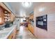 Galley kitchen featuring wood cabinets, sleek appliances, and tile backsplash at 2150 Main St, Beech Grove, IN 46107