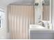 Bright bathroom features a shower with curtain and a stylish sink with modern faucet at 2336 Sycamore St, Columbus, IN 47201