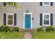 Close up view of the front of the house featuring a bright blue front door with black shutters and landscaping at 2336 Sycamore St, Columbus, IN 47201