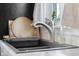 Close-up of a modern, stainless steel kitchen faucet above a modern, dark sink at 2336 Sycamore St, Columbus, IN 47201