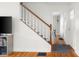 Bright and airy staircase featuring hardwood floors, white walls, and a stained wood banister at 2336 Sycamore St, Columbus, IN 47201