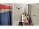 Neat bathroom with well-stocked vanity, framed mirror, decorative stars, flag, and a colorful shower curtain at 2548 N Letterman Rd, Paragon, IN 46166