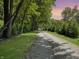 Gravel driveway lined with mature trees leading to the serene and private property at 2548 N Letterman Rd, Paragon, IN 46166