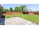 Spacious backyard featuring a well-maintained lawn, wood fence, and a charming red storage shed at 3126 Oakmont Dr, Lapel, IN 46051
