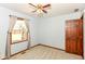 Cozy bedroom featuring neutral carpet, a window with curtains, ceiling fan, and a wooden door at 3126 Oakmont Dr, Lapel, IN 46051