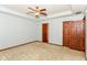 Large bedroom with neutral carpet, ceiling fan, and dark stained doors at 3126 Oakmont Dr, Lapel, IN 46051