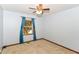Carpeted bedroom with a ceiling fan, and a window with blue curtains framing the view outside at 3126 Oakmont Dr, Lapel, IN 46051