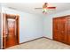 Carpeted bedroom features wood trim, ceiling fan, and a wood paneled closet with double doors at 3126 Oakmont Dr, Lapel, IN 46051