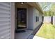 Inviting front entrance with a glass storm door, neutral siding, and a glimpse of the landscaped yard at 320 Red Tail Ln, Indianapolis, IN 46241
