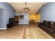 Bright and spacious living room with hardwood floors, a leather sofa, and an open connection to the kitchen at 320 Red Tail Ln, Indianapolis, IN 46241