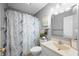 Bathroom with white vanity and sink, toilet, tub and blue and white patterned shower curtain at 3334 Old Field Ln, Columbus, IN 47203
