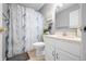 Bright bathroom features a single sink vanity and toilet, tub and blue and white patterned shower curtain at 3334 Old Field Ln, Columbus, IN 47203