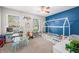 Bright bedroom features a unique house frame bed, toy kitchen, and large windows at 3334 Old Field Ln, Columbus, IN 47203