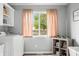 Charming laundry room with neutral tones, modern appliances, and decor, complemented by natural light from the window at 3334 Old Field Ln, Columbus, IN 47203