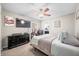 Calm main bedroom with soft lighting, furniture set, TV, and ceiling fan, providing a restful and inviting personal space at 3334 Old Field Ln, Columbus, IN 47203