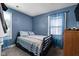 This bedroom features a black metal bed frame and blue colored walls and curtains at 3433 Brewer Dr, Indianapolis, IN 46222
