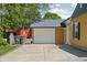 Detached garage with white door and driveway, next to the yellow house at 3433 Brewer Dr, Indianapolis, IN 46222