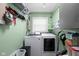 Compact laundry room with washer, dryer, shelving, and green walls at 3433 Brewer Dr, Indianapolis, IN 46222