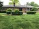 Brick home's backyard featuring a well-maintained lawn, brick patio, and mature landscaping at 3619 31St St, Columbus, IN 47203
