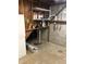 Unfinished basement utility area featuring a sump pump, shelves, and exposed pipes at 3619 31St St, Columbus, IN 47203
