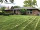 Exterior view of brick ranch home with mature lawn, classic chimney, and tidy landscaping at 3619 31St St, Columbus, IN 47203